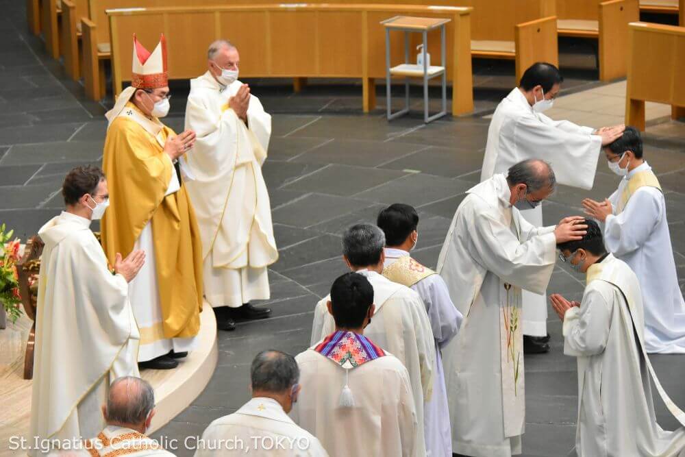 年間第25主日ミサ司式のグエン・ミン・トアン 神父と、越智 直樹 神父の叙階式の様子。イエズス会の司祭たちから按手を受ける。